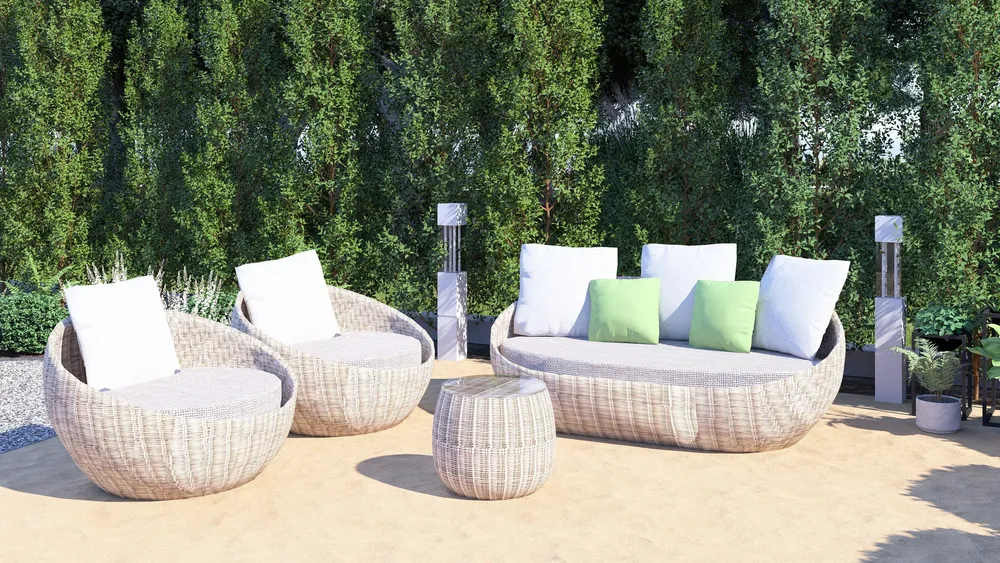 Woven lounge furniture in front of a hedge